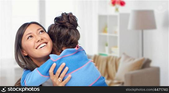 family, motherhood and people concept - happy mother and daughter hugging over over home room background. happy mother and daughter hugging at home. happy mother and daughter hugging at home