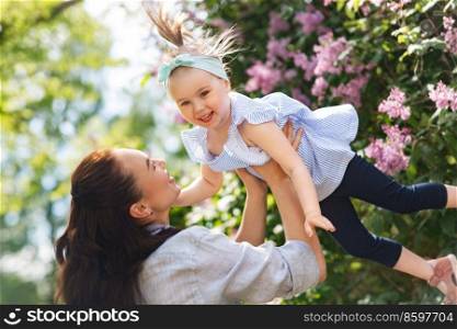 family, motherhood and people concept - happy mother with little daughter at summer park or garden. happy mother with little daughter at summer park