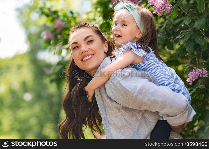family, motherhood and people concept - happy mother with little daughter having fun at summer park or garden. happy mother with little daughter at summer park