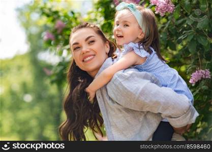 family, motherhood and people concept - happy mother with little daughter having fun at summer park or garden. happy mother with little daughter at summer park