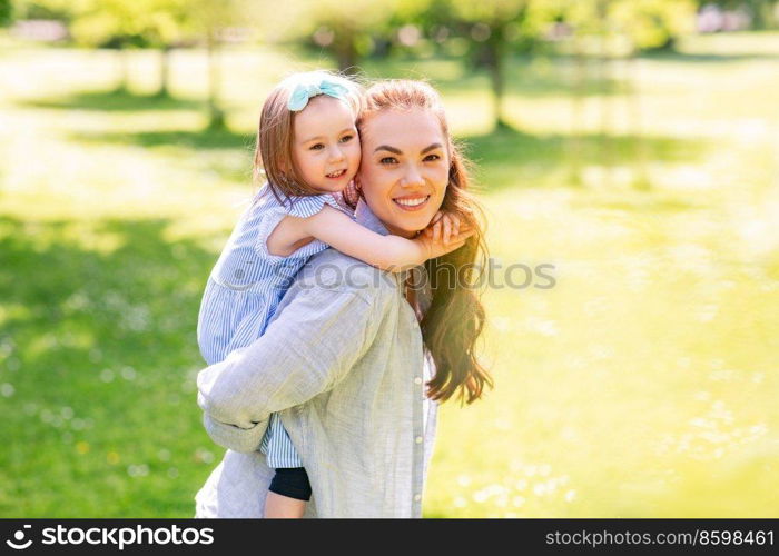 family, motherhood and people concept - happy mother with little daughter having fun at summer park. happy mother with little daughter at summer park
