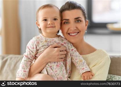 family, motherhood and people concept - happy smiling mother with little baby daughter at home. happy mother with little baby daughter at home