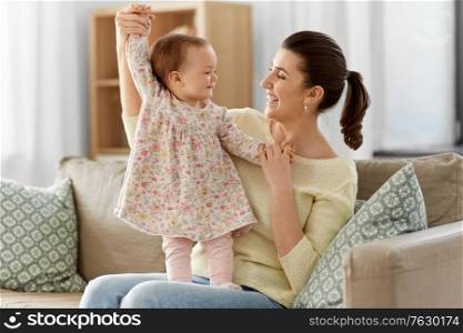family, motherhood and people concept - happy smiling mother with little baby daughter at home. happy mother with little baby daughter at home