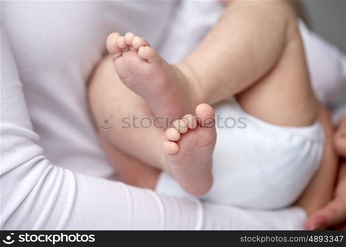 family, motherhood, parenting, people and child care concept - close up of newborn baby in mother hands