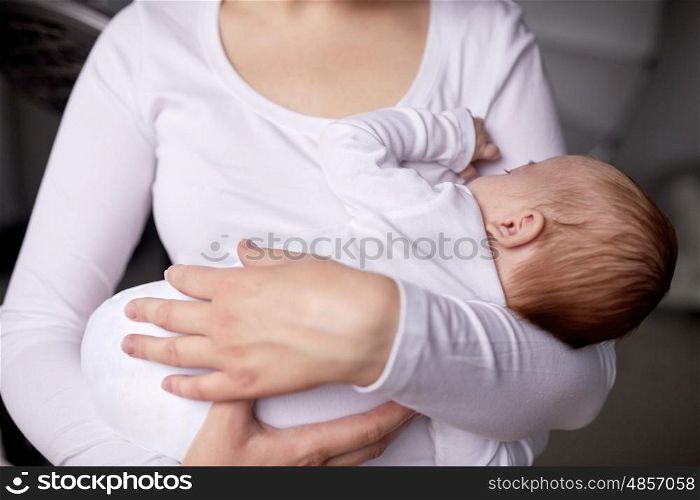 family, motherhood, parenting, people and child care concept - close up of mother holding newborn baby