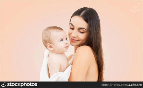 family, motherhood, parenting, people and child care concept - happy mother holding adorable baby over beige background