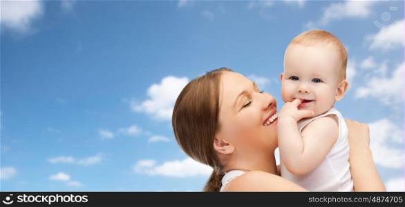 family, motherhood, parenting, people and child care concept - happy mother holding adorable baby over blue sky background
