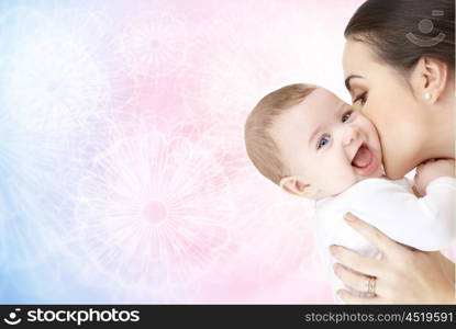 family, motherhood, parenting, people and child care concept - happy mother kissing adorable baby over rose quartz and serenity patterned background