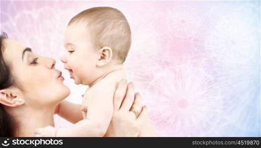 family, motherhood, parenting, people and child care concept - happy mother kissing adorable baby over rose quartz and serenity patterned background