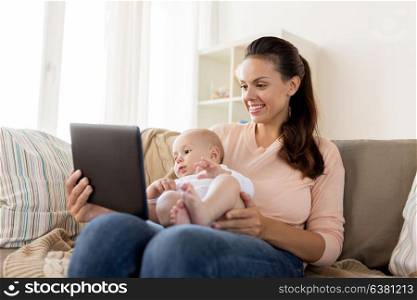 family, motherhood, technology and people concept - happy mother and little baby boy with tablet pc computer at home. happy mother and baby boy with tablet pc at home
