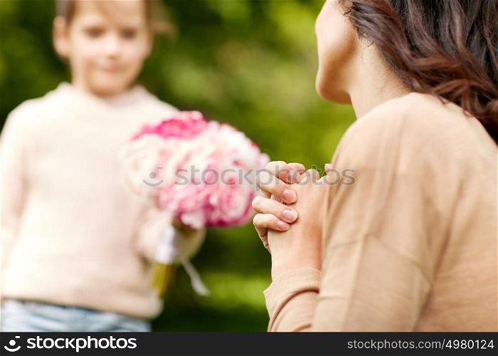 family, mothers day, holidays and people concept - happy woman and girl with flowers outdoors. happy woman and girl with flowers outdoors