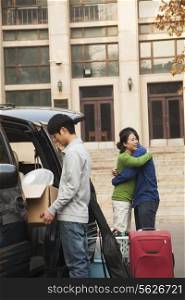 Family moving their son into dormitory on college campus