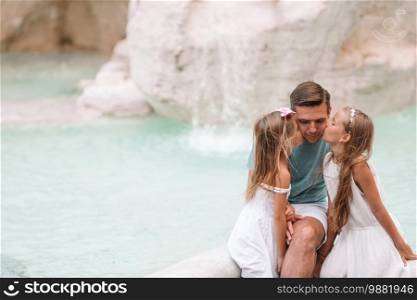 Family near the Fountain of Trevi in Rome. Happy kids and dad enjoy their european vacation in Italy. Happy kids and dad enjoy their european vacation in Italy