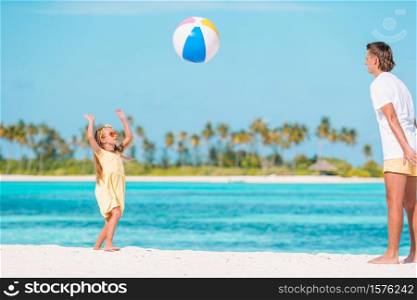 Family of dad and lid playing with ball on the beach. Happy family on the beach with ball