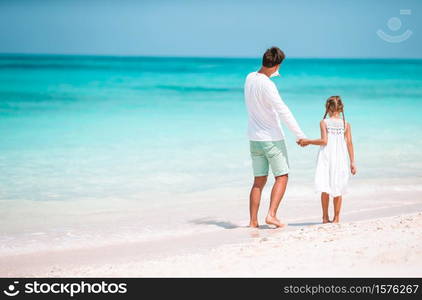 Family of father and his daughter on the beach vacation. Little girl and happy dad having fun during beach vacation