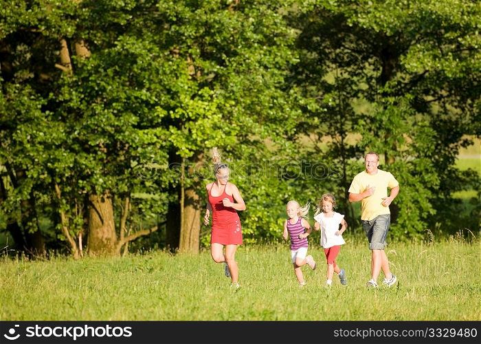 Family of five exercising outdoors, jogging thru the woods