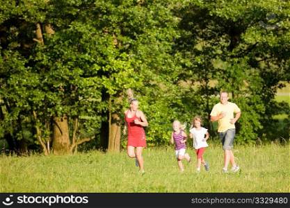 Family of five exercising outdoors, jogging thru the woods