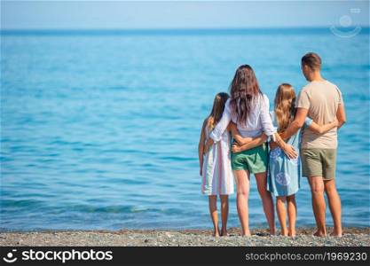 Family of four have fun together on the beach vacation. Young family on vacation have a lot of fun