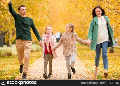 Family of four in autumn park outdoors. Portrait of happy family of four in autumn day