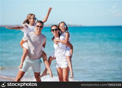 Family of four on the beach vacation. Happy family on the beach during summer vacation