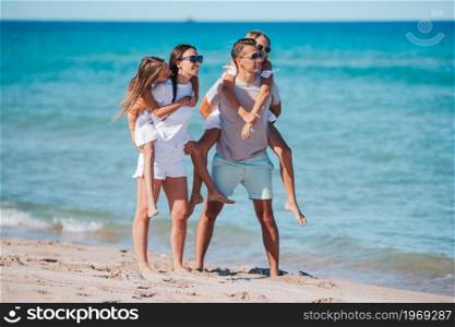 Family of four on the beach vacation. Young family on vacation have a lot of fun