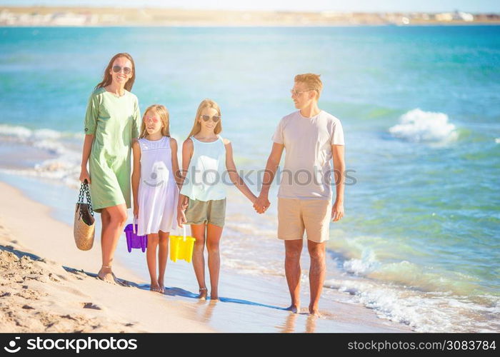 Family of four on the beach vacation. Young family on vacation have a lot of fun