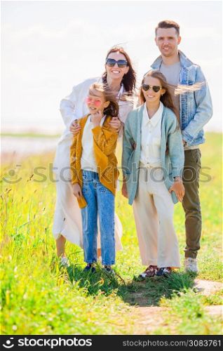 Family of four on the lake outdoors on their vacation. Adorable family on vacation on the lake