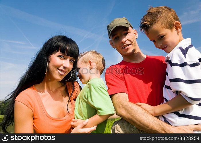 Family of four outdoors at a wonderful summer day