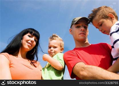 Family of four outdoors at a wonderful summer day