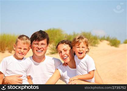 Family of four portrait on sandy coast