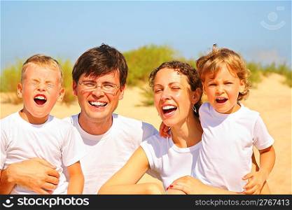 Family of four portrait on sandy coast