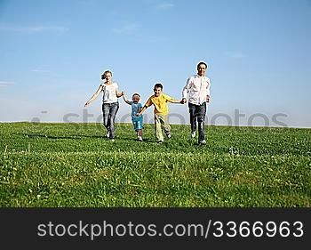 family of four running grass sky