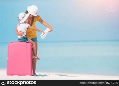 Family of mom and little kid on the beach wih luggage. Family on the white beach wih baggage