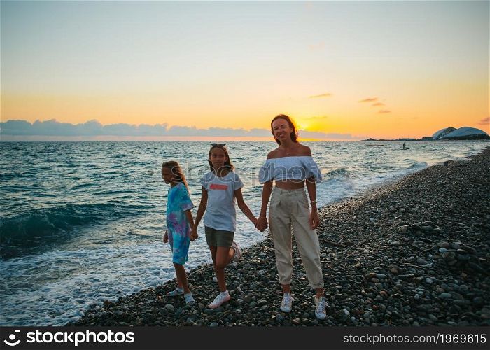 Family of mother and kids on the beach vacation. Adorable little girls and young mother on tropical white beach