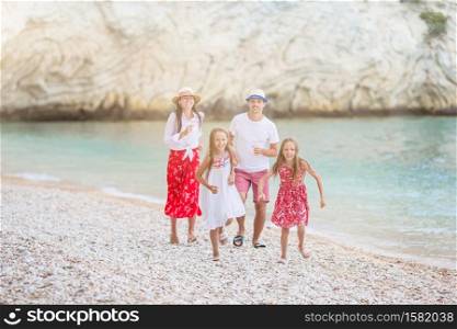 Family of parents and children on the beach having fun. Young family on vacation have a lot of fun