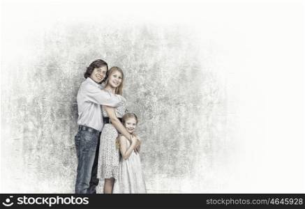 Family of three. Happy family of mother father and daughter against cement wall