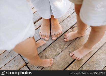 Family of three. mother and two kids playing outside. Legs of unrecognizable people. Happy family standing outdoors in warm summer day. Family concept. People on vacation enjoying nature.. Family of three. mother and two kids playing outside. Legs of unrecognizable people. Happy family standing outdoors in warm summer day. Family concept. People on vacation enjoying nature