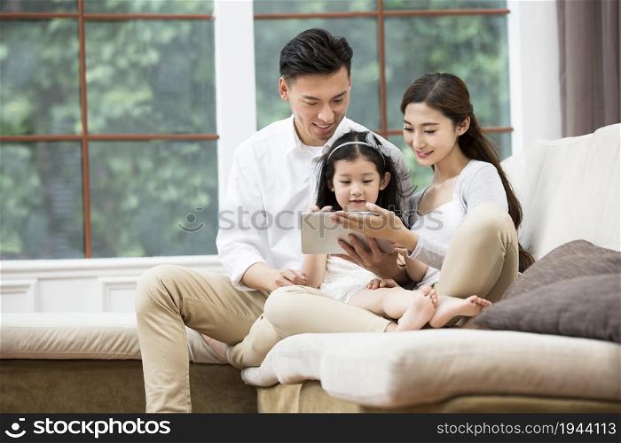 Family of three playing a tablet computer