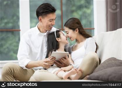 Family of three playing a tablet computer