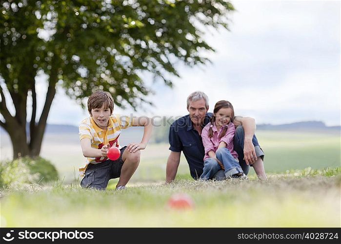 family of three sitting on the grass