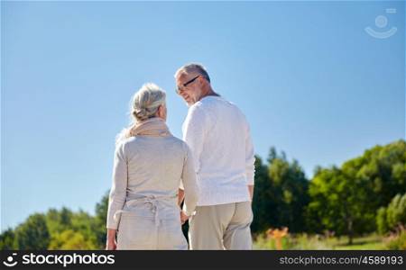 family, old age, leisure, summer and people concept - happy senior couple walking outdoors