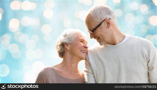 family, old age, love and people concept - happy senior couple over blue holidays lights background