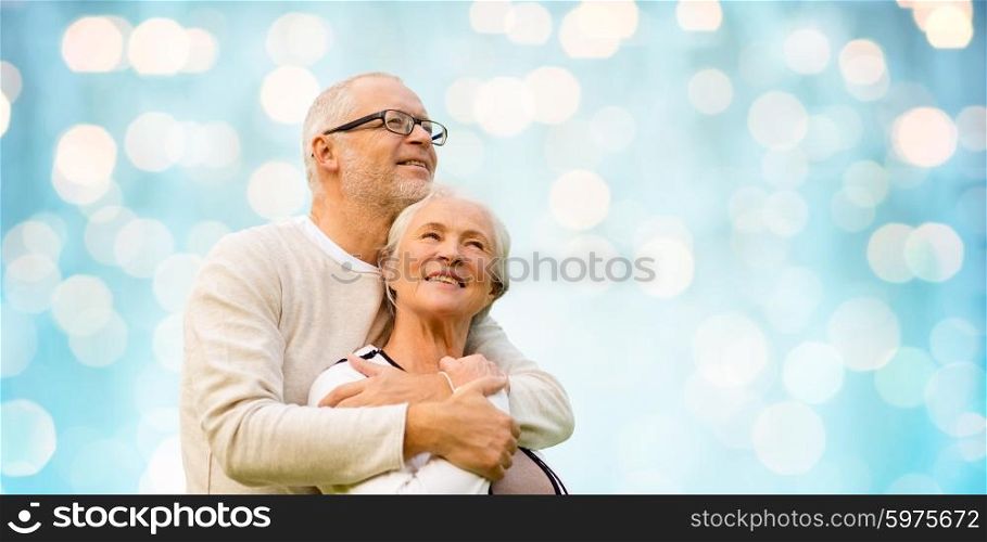 family, old age, love and people concept - happy senior couple over blue holidays lights background