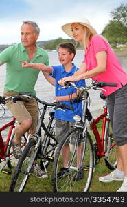 Family on a bike ride standing by a lake