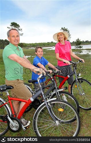 Family on a bike ride standing by a lake