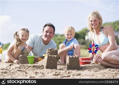 Family on beach making sand castles smiling