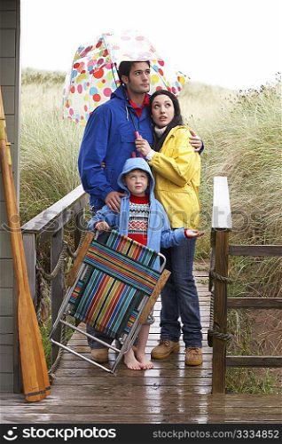 Family on beach with umbrella