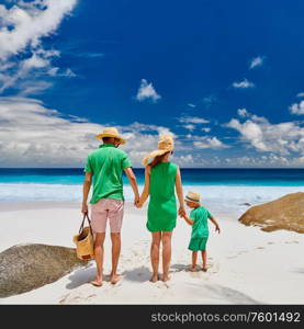 Family on beautiful Anse Intendance beach, young couple in green with three year old toddler boy. Summer vacation at Seychelles, Mahe.