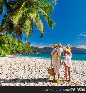 Family on beautiful Anse Soleil beach, young couple in white with three year old toddler boy. Summer vacation at Seychelles, Mahe.