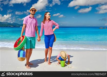 Family on beautiful Anse Soleil beach, young couple with three year old toddler boy. Summer vacation at Seychelles, Mahe.